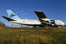 A parked aircraft on a grassy field.