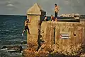 Jumping off the Malecón with the Morro Castle in the background