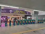 The fare gates to/from the station. The Avenue K shopping mall's concourse level can be seen.