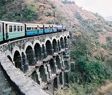 A train crossing a bridge with several arches