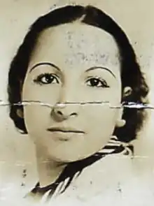 A young Moroccan woman with dark hair and eyes, with eyebrows shaped into a thin round arch