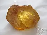 A dark gold transparent rough lump of resin