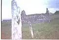 Headstone on the grave of St Cummin, with the old church of St Cummin (dated to pre-8th Century)