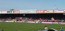 One of the stands of the Bootham Crescent association football ground, with supporters waving flags and a grass field below