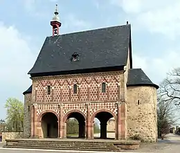 A stand-alone gatehouse surrounded by trees.