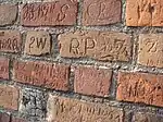 Inscriptions carved by local figures through the ages, on the wall of St. Bartholomew's Church