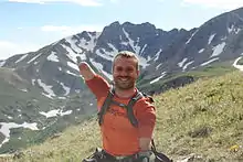 Kyle Maynard wearing an orange T-shirt and a black backpack