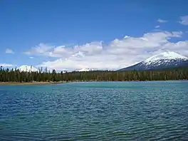 View to the northeast across Lava Lake with three volcanic mountains in the background: South Sister, Broken Top, and Mount Bachelor.