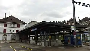 Three-story building with hip roof and adjoining canopy-covered shelter