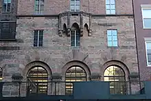 The "corner pavilion" on Lexington Avenue. The facade contains alternating stone and brick bands at the second story, and there is an angular brick-and-stone balcony above the third story.