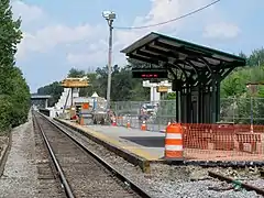 New platform installed and pedestrian overpass under construction behind the old station in August 2012