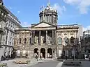 The town hall, at the head of Castle Street, is a sandstone-brick building with a neo-classical central portico entrance under a cylindrical and dome-topped clock tower.