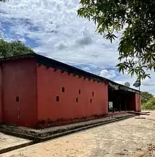 A building with red walls and a flag in front