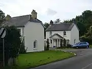 white-painted and slate-roofed lodge houses either side of a gateway