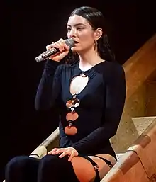 Lorde singing holding a microphone