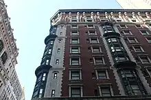 Easternmost bays on the 29th Street facade of the original building. The facade is largely made of brick, terracotta, and limestone, but there are curved metal bays of windows as well.