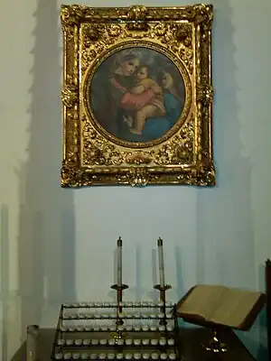 Madonna and Child with a votive candle rack and prie-dieu in a Methodist church