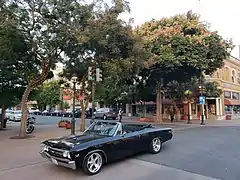 Picture of Main Street in Salinas with a vintage car, holiday lights and trees.