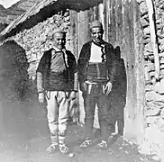 Two young men of Štirovica showing off opingas (leather skin footwear).