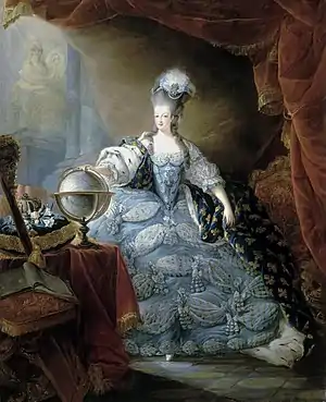 A woman with a pouf wears a voluminous blue dress with a train of fleur-de-lis.