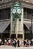 The "Great Clock" on the corner of the Marshall Field & Company Building of 1891–1892, above a crowd of pedestrians at North State and Washington Streets, erected 1897