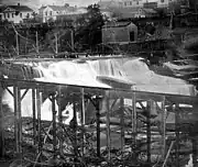 Waterfall surrounded by sawmills and scaffolding