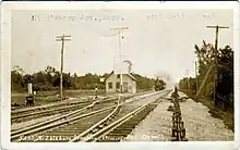 A postcard of a small structure at a railroad junction