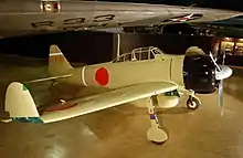 A propeller aircraft on display in a museum. The wing tips are folded up.