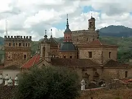 A complex of various buildings including towers made of natural stones.