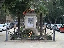 Picture of the monument, a marble stone that has Spanish-language text written on it.