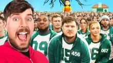 MrBeast stands left in a red jumpsuit with an excited expression on his face. Behind him is a crowd of people in green hoodies with numbered patches. Behind the crowd is a tree with no leaves and an animatronic girl taller than the crowd. To the right is a small house-like structure in the background.