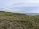 Mynydd Bach round cairn in the foreground, with Barclodiad y Gawres on the skyline