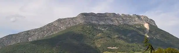 Rocky ridges dominating the forest with a scree to the right.