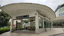 Curved entrance to the Farrer Park station, at ground level in front of a shopping mall