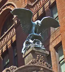 Massive bronze sculpture by Louis St. Gaudens of an eagle tending a nest of baby eaglets above the street entrance