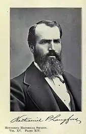 B&W photograph of a black haired man with a full beard.