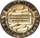 Gold medallion emblazoned with the motto "Expanding Our Understanding of the World"