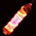 Glass tube shining orange light with a wire wound over it