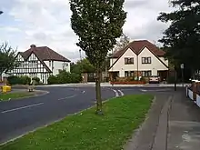 A row of suburban houses with white gabled ends and black timber beams