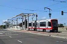 A light rail train crossing a concrete bridge