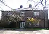 A brick building in two storeys with a French window