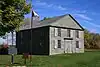 Exterior view of the Old Hay Bay Church with Canada flag and plaque out front