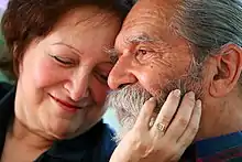 A woman touches a man's face.