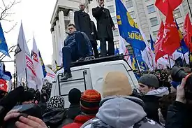 Speakers addressing demonstrators with flags