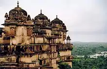 A palace overlooking a forest and a river