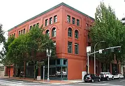 Photograph of a four-story, brick building on an urban street corner.