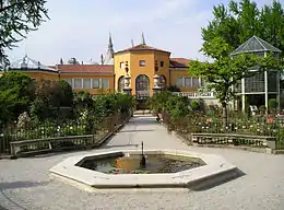 A garden with a church in the background.