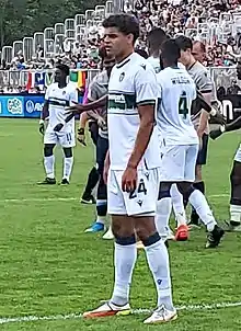 Player standing up on the pitch during a break in the match