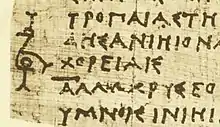 Detail of P.Berol. inv. 9875 col. v  (late fourth or early third century BCE), showing the bird-shaped coronis at the beginning of the "sphragis" in the Persae of Timotheus of Miletus.