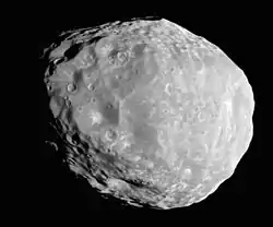 An irregular body, whose outline looks like an approximate circle in this image. It is illuminated from the bottom-left. The terminator runs from the top-left to bottom-right. The surface is covered by craters.